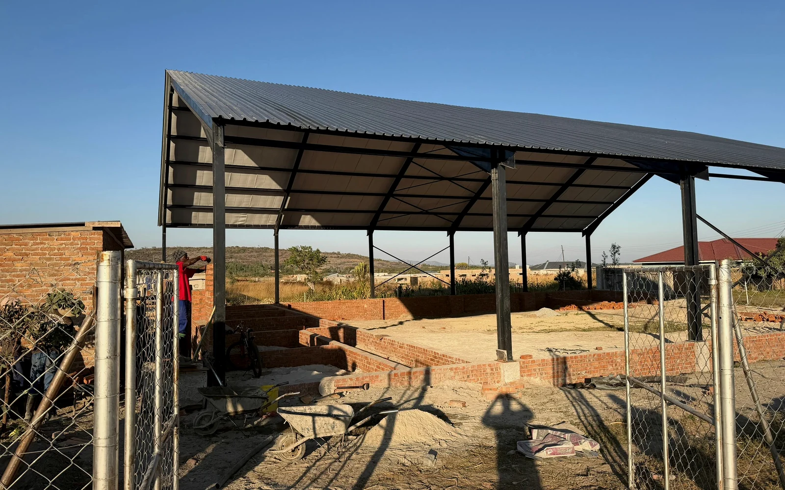 Completed steel roof structure standing over a construction site